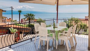 A terrace with a table and chairs, overlooking the sea. - Beautiful Home in Icici With Wifi and 3 Bedrooms (Opatija)