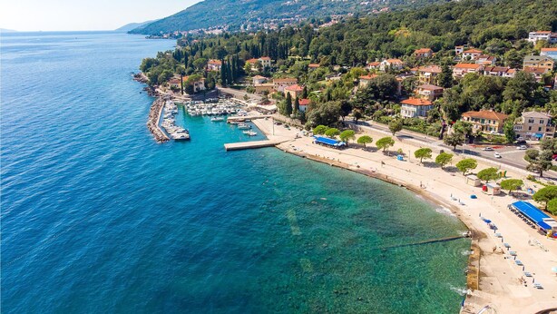 An aerial view of a coastal town with a marina, clear blue waters, and a mix of residential buildings. - Beautiful Home in Icici With Wifi and 3 Bedrooms (Opatija)