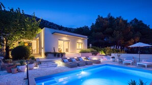 A modern house with a swimming pool, outdoor seating, and a well-lit entrance. - Amazing Home in Naklice With Wifi and 2 Bedrooms (Omis)