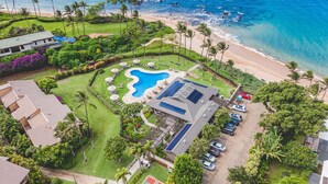 Eine Luftaufnahme eines Resorts mit Schwimmbad, Strand und Palmen.