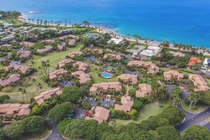 Luchtbeeld van een kustgebied met huizen, een strand en een zwembad.