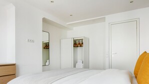 A bedroom with a bed, a wardrobe, and a mirror. - Modern Landstraße 1BR, walk to Metro U1 and Hauptbahnhof, by Blueground (Vienna)