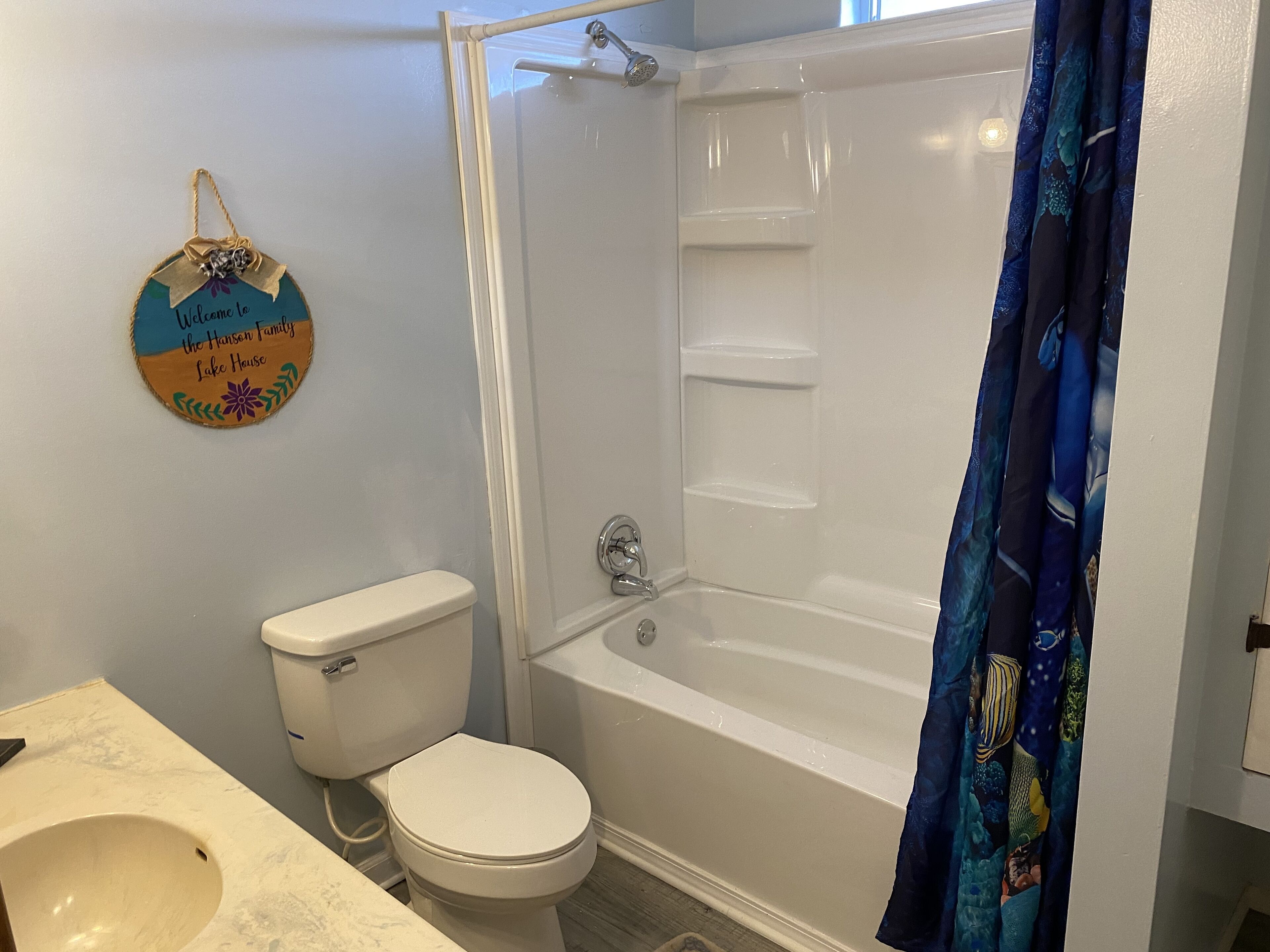Et badeværelse med toilet, vask og badekar.