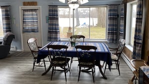 A dining area with a large table, six chairs, and a chandelier. - Romantic House on the Lake-Hot Tub Pet Friendly-kayaks-Fishing Boat. Sleeps 8 (Pleasant Lake)