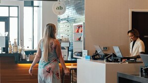 A hotel reception area with a counter, computers, and a person working behind it. - Hyatt Centric Downtown Denver (Denver)