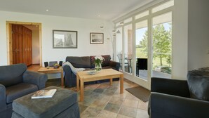 En moderne stue med sofa, sofabord og spiseplads.