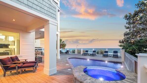 A pool area with a hot tub, lounge chairs, and a view of the ocean. - Luxe group-friendly beachfront escape with pool, hot tub, & expansive Gulf views (West Panama City Beach)
