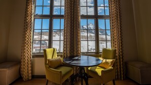 A room with a large window, two yellow chairs, a round table, and a wooden ceiling. - Three Bedroom Mountain Chic 6th Floor Penthouse with Amazing View 3 Condo - No Cleaning Fee! by RedAwning (Crested Butte)