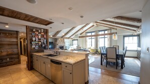 A spacious kitchen with a large island, wooden beams, and a stone fireplace. - Three Bedroom Mountain Chic 6th Floor Penthouse with Amazing View 3 Condo - No Cleaning Fee! by RedAwning (Crested Butte)