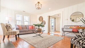Un salon comprenant un canapé, des fauteuils, une table basse et un tapis.