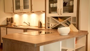 A modern kitchen with a central island, built-in cabinets, and a variety of appliances. - Das Backhaus 2 (Stoltebuell)