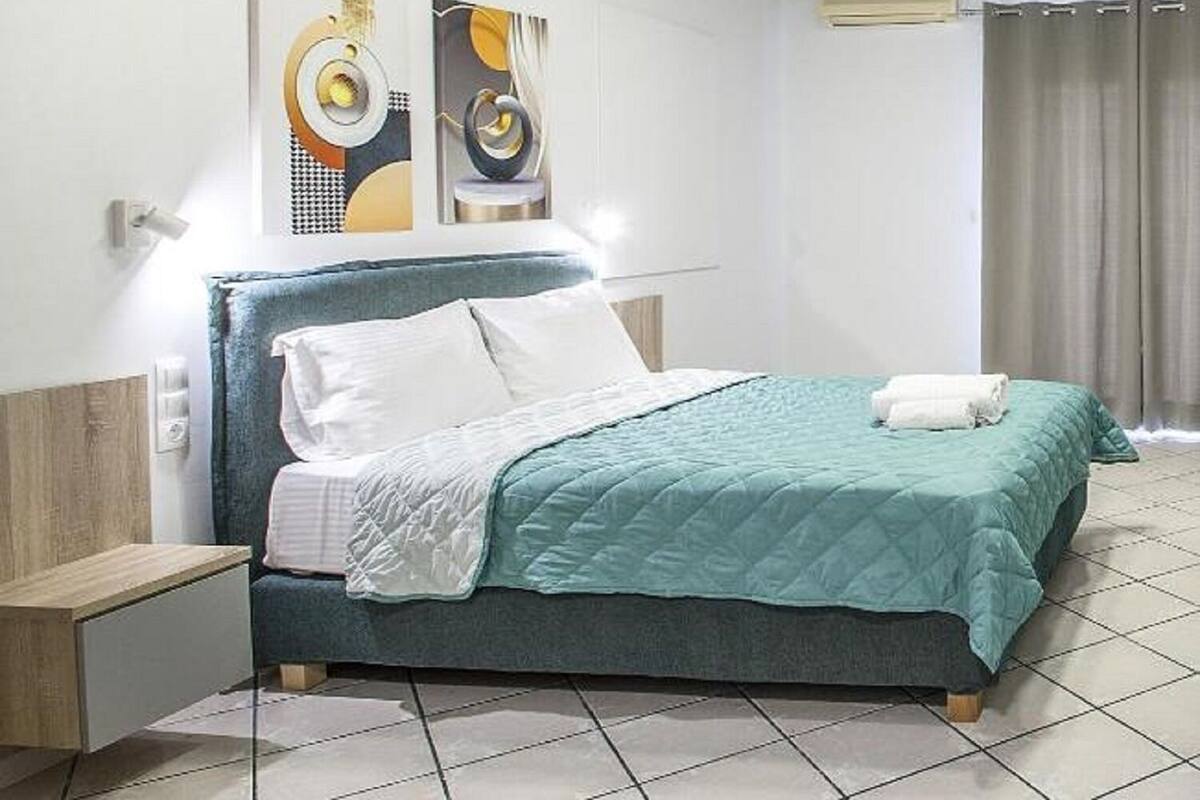 Una habitación de hotel moderna con cama, mesita de noche y obras de arte en la pared.