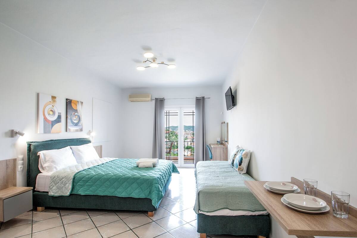 Una habitación de hotel moderna con dos camas, una mesa de comedor y un televisor.