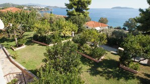 A residential area with a view of the sea, surrounded by greenery and houses with red-tiled roofs. - Olga Villa (Skiathos)