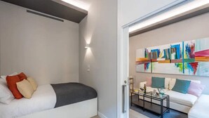 A modern living room with a sofa, a coffee table, and a painting on the wall. - Sweett | Duomo 2A - Two Bedroom Apartment, Sleeps 4 (Milano)