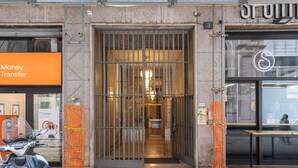 A building entrance with a metal gate, a sign for 'Money Transfer', and a 'Change' sign.