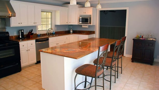 A kitchen with a large island, bar stools, a microwave, and a dishwasher. - Stunning Home In A Leafy And Quiet Neighborhood (Jackson)