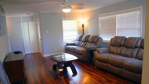 A living room with a wooden floor, a ceiling fan, a sofa, and a coffee table. - Stunning Home In A Leafy And Quiet Neighborhood (Jackson)