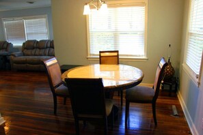 A dining area with a round table and four chairs, a sofa, and a lamp. - Stunning Home In A Leafy And Quiet Neighborhood (Jackson)