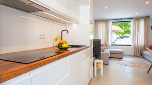 Una cocina moderna con encimera de madera, un tazón de fruta y un televisor.