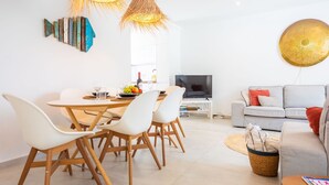 Un espacio habitable moderno con comedor, sofá y televisor.