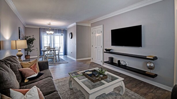 Una sala de estar con sofá, mesa de centro, televisor y estanterías.
