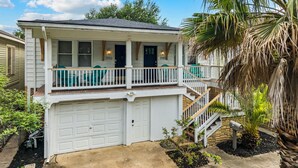 A two-story house with a front porch, a garage, and a staircase leading to the second floor.