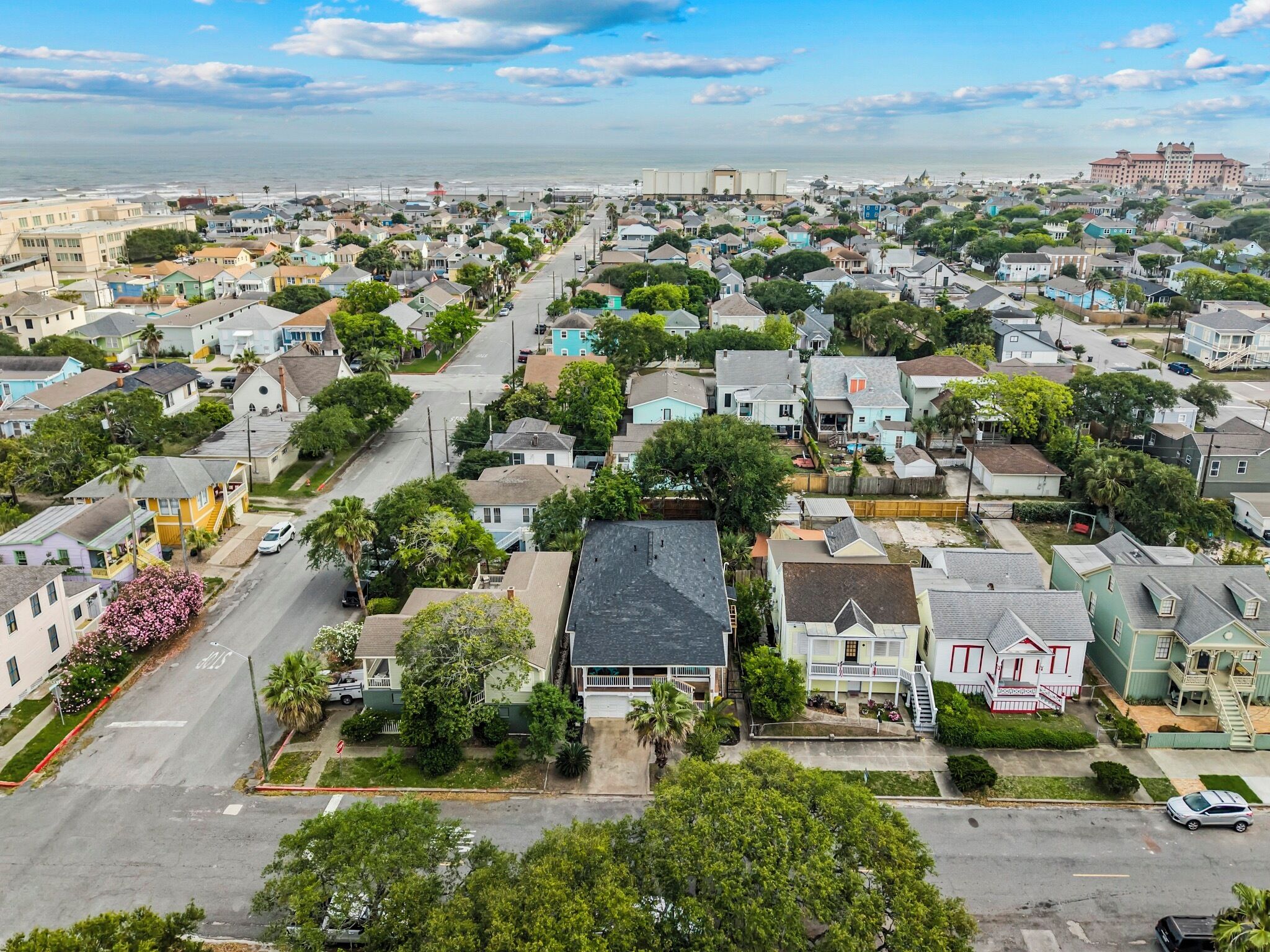 A residential area with houses, a road, and a large building in the background.