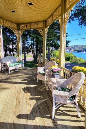 A covered outdoor area with wicker furniture and potted plants. - Time for fall color viewing and winter fun planning. Lots of room for your group (Hancock)
