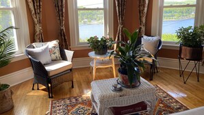 A cozy room with wicker furniture, a patterned rug, and potted plants. - Plan for summer fun and fall color viewing.  Plenty of room for the family. (Hancock)