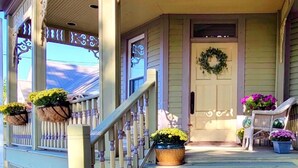 A porch with a wooden railing, a door with a wreath, and potted plants. - Plan for summer fun and fall color viewing.  Plenty of room for the family. (Hancock)