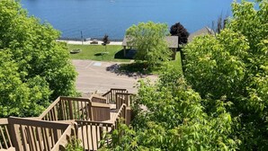 A view of a lake with a dock and a building in the background. - Plan for summer fun and fall color viewing.  Plenty of room for the family. (Hancock)