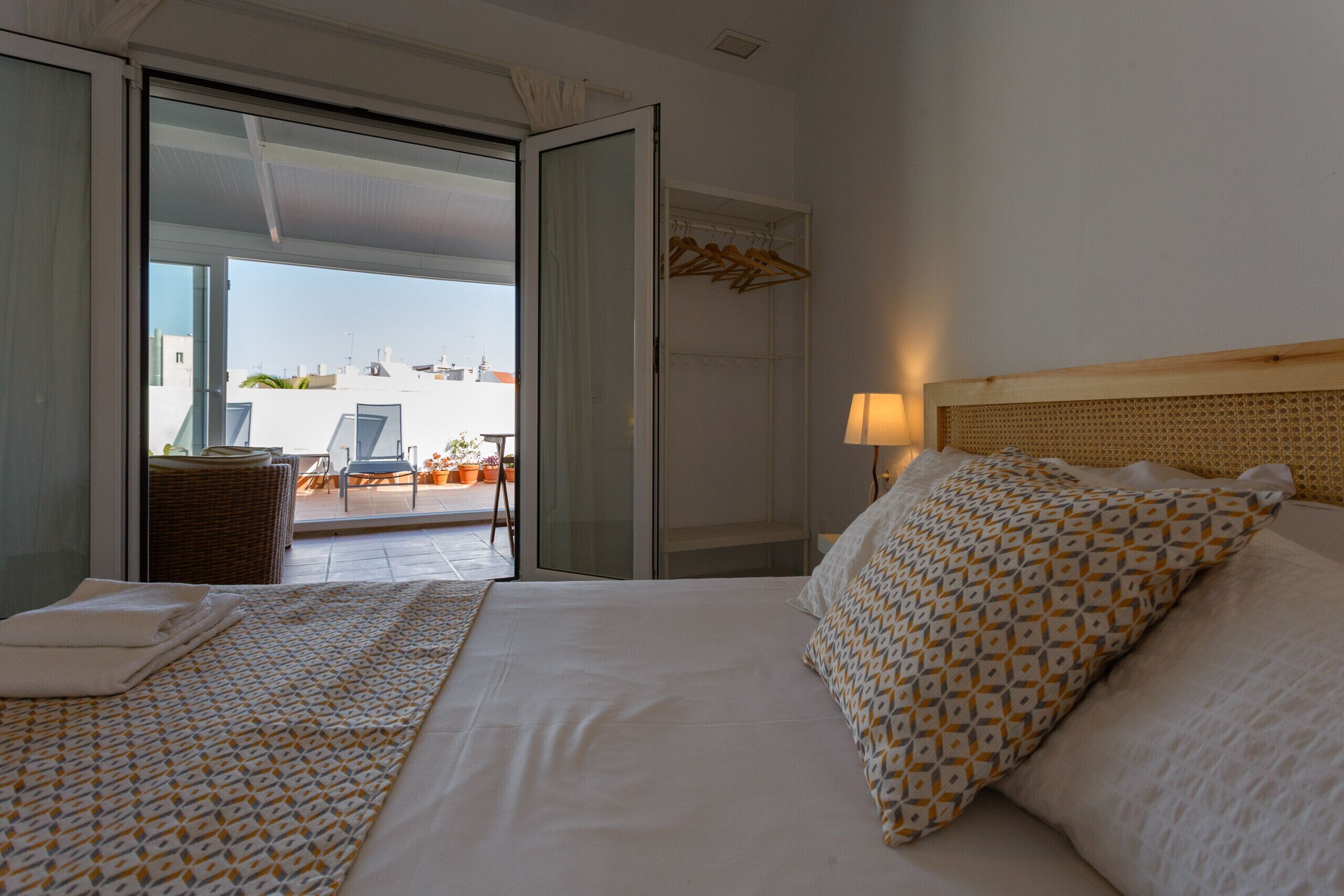 Una habitación de hotel con cama, una silla, una mesa y vistas al exterior.