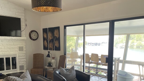 Een moderne woonkamer met lederen banken, een groot raam en uitzicht op de omgeving.
