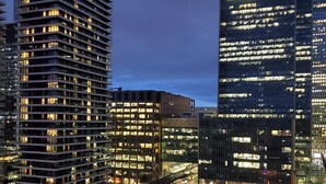 A high-rise building with illuminated windows, a modern architectural design, and a visible sign for J.P. Morgan. - Captivating 2-bed Apartment in Canary Wharf London (London)