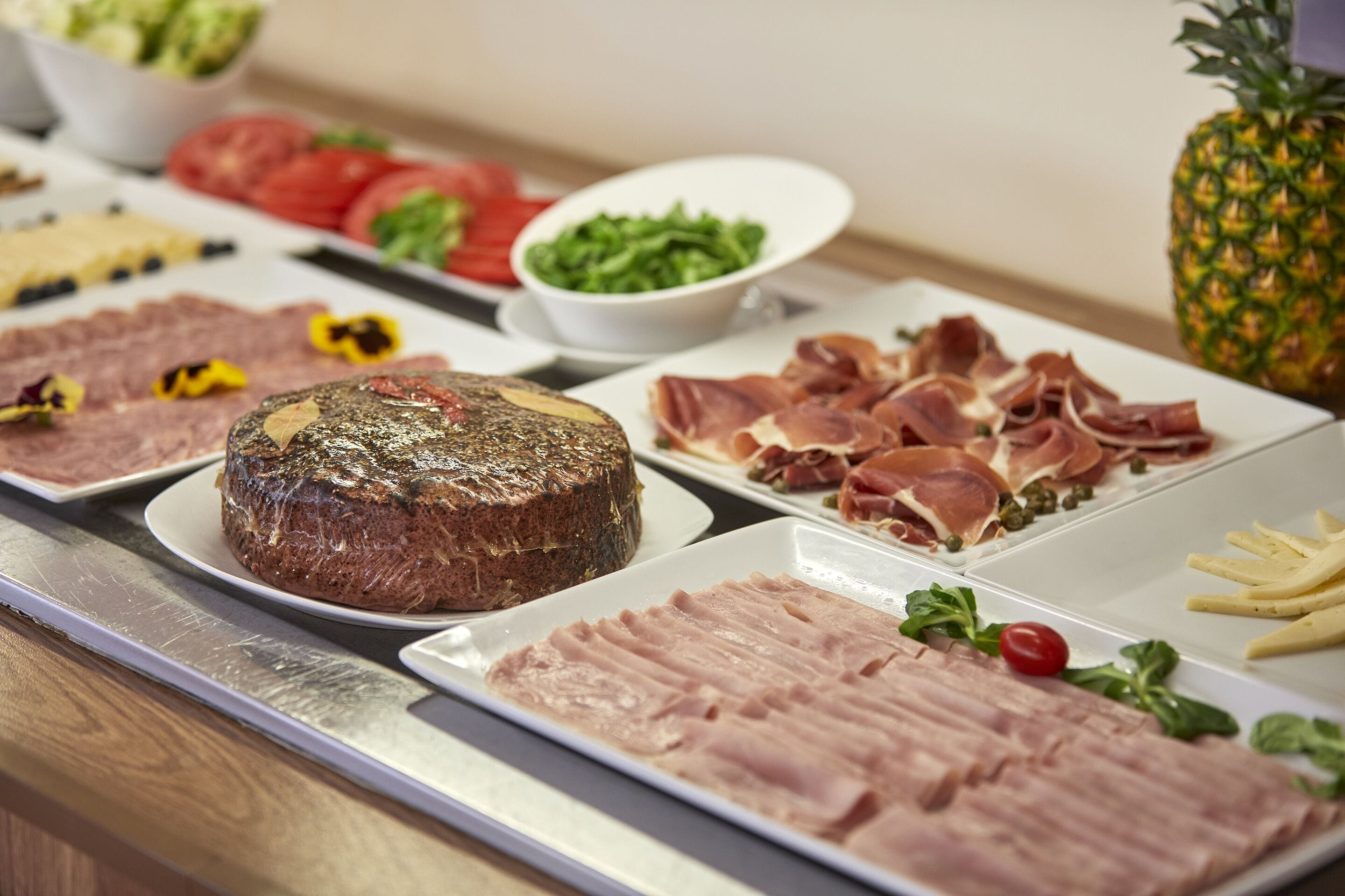 Un bufé con diversas opciones de comida, incluyendo carnes, ensaladas y frutas.