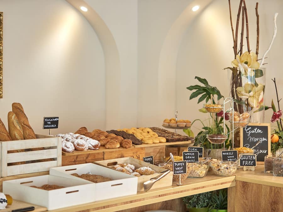 Mostrador de una panadería con diversos productos horneados y secciones identificadas para opciones sin gluten.