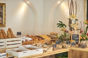 A bakery display with various baked goods and labeled sections for gluten-free options. - Nura Santa Ponsa Pins (Calvia)