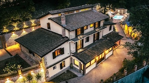 Edifício com vários andares e um pátio, com piscina e iluminação externa.