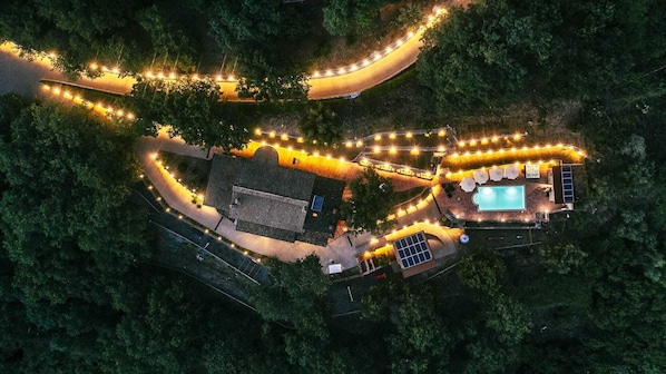 Vista aérea de um resort com piscina, espreguiçadeiras e área coberta.