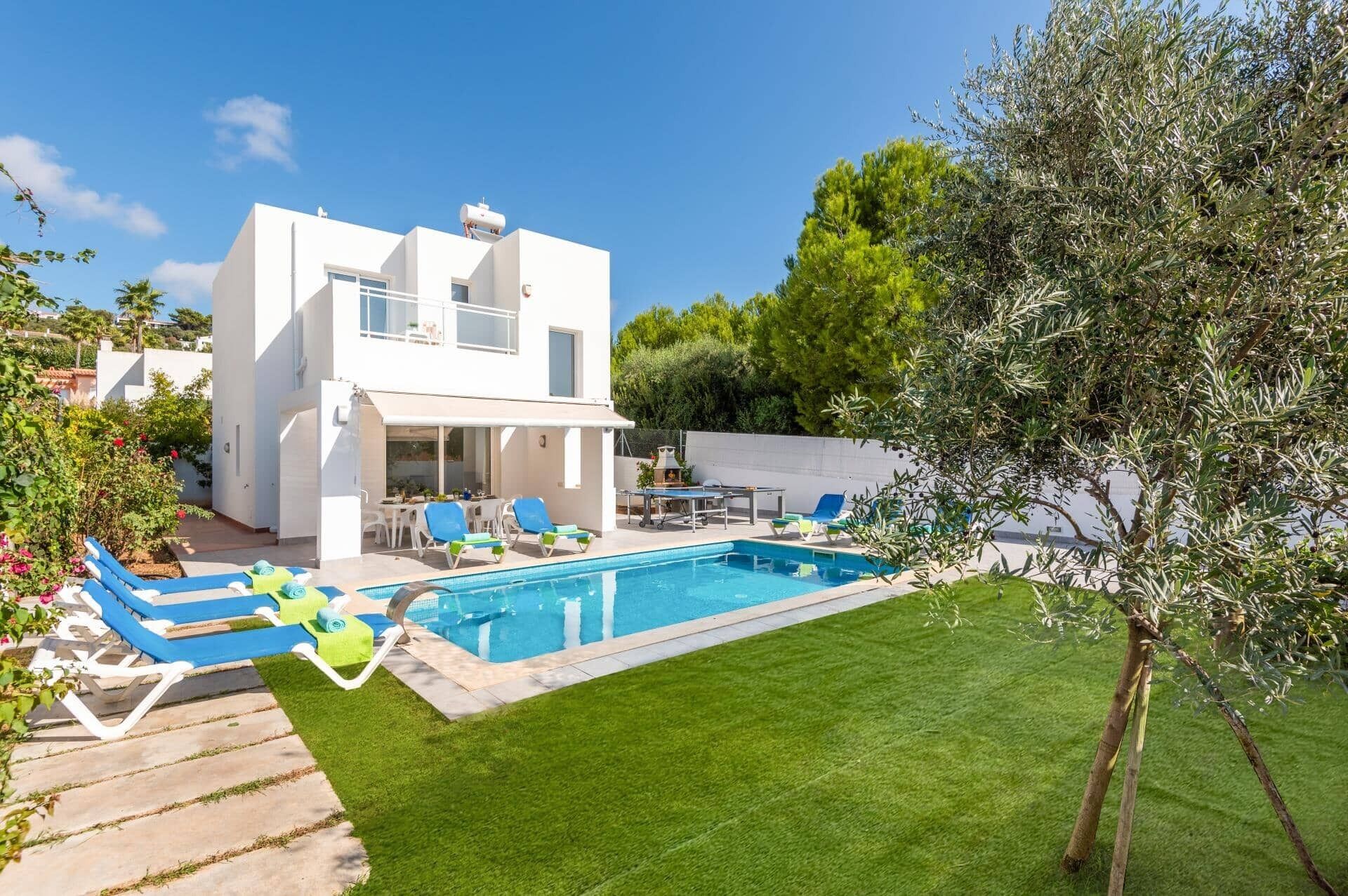 A modern two-story house with a swimming pool, a covered patio, and a well-maintained lawn.