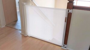 Une pièce avec un plancher en bois, une porte blanche dotée d’une moustiquaire et une fenêtre donnant sur l’extérieur.