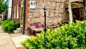 A brick building with a stone facade, a bench, and a sign for Murphy's. - Unique wine cellar suite in the heart of Downtown Hermann! (Hermann)