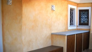 Una cocina con una banca integrada, un ventanal con celosía de metal y una encimera.