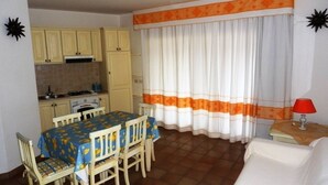 Un espacio habitable compacto con comedor, kitchenette y sofá.