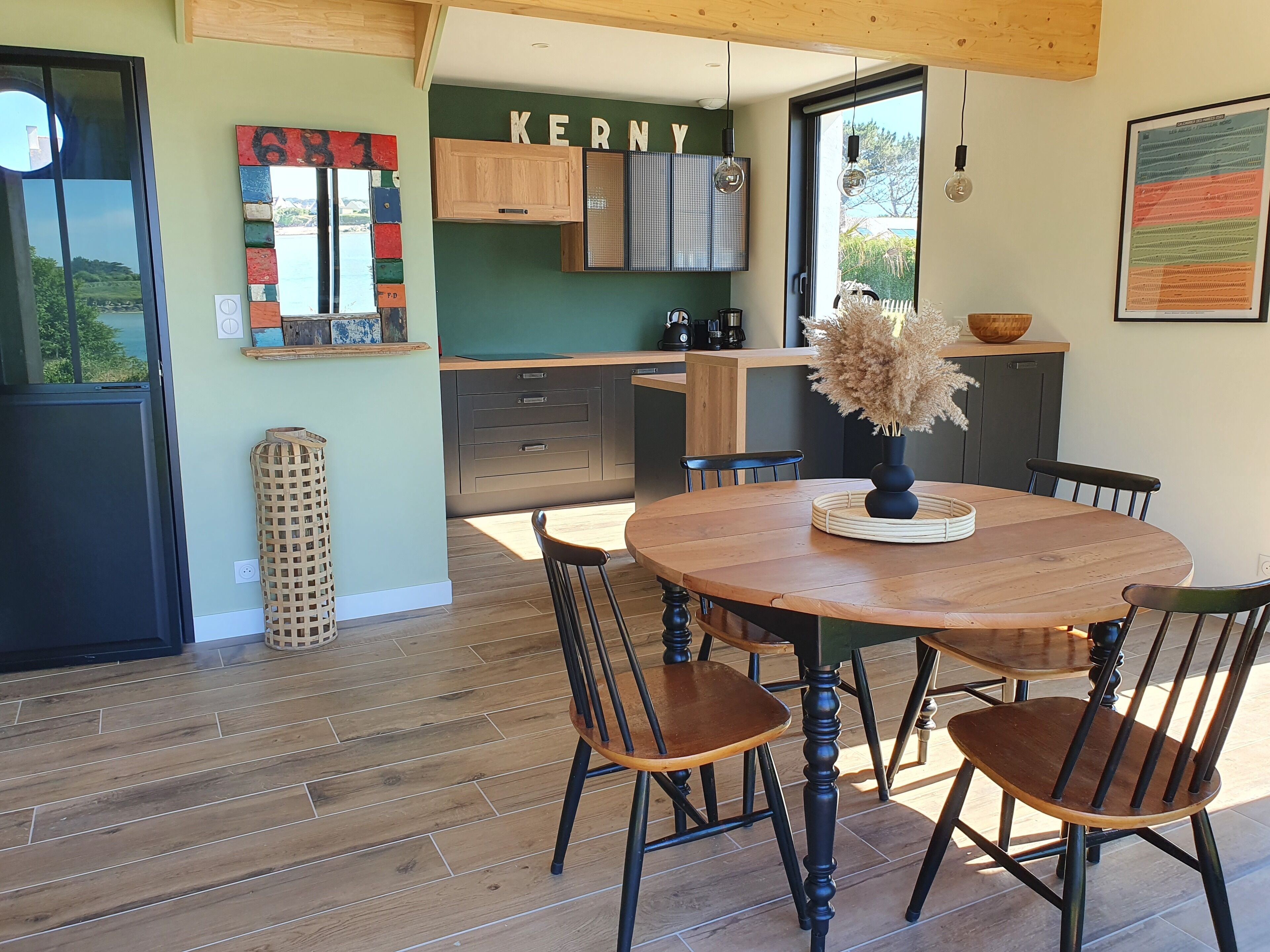 Una cocina moderna con armarios de madera, horno integrado y comedor con mesa y sillas de madera.