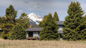 Een huis met een berg op de achtergrond, omringd door bomen.