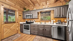 Eine moderne Küche mit Holzausstattung, Edelstahlgeräten und einem Einbauofen.