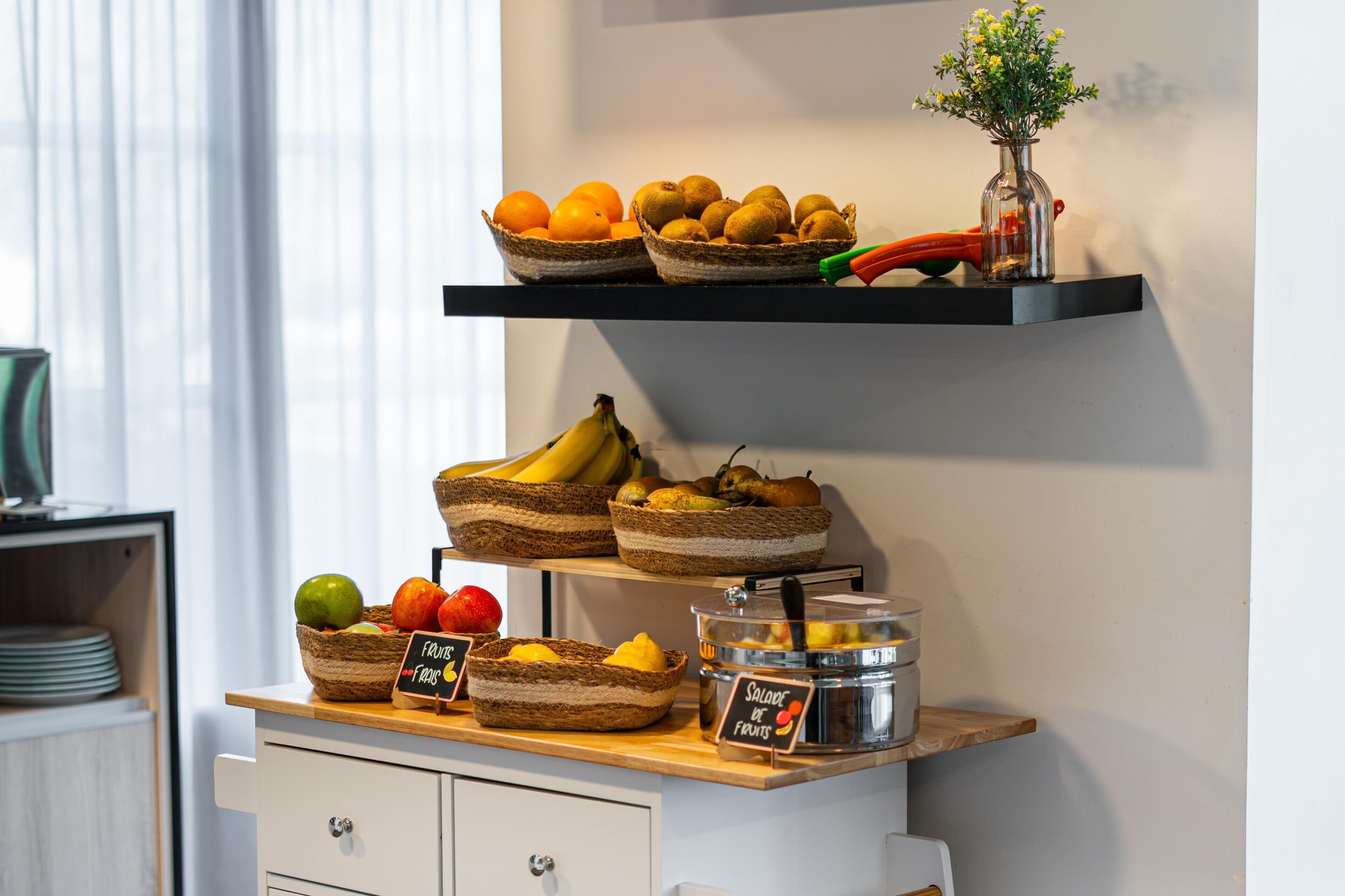 A breakfast buffet with various fruits and a sign indicating 'Salad of Fruits.'