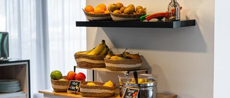 A breakfast buffet with various fruits and a sign indicating 'Salad of Fruits.'